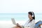 Lifestyle freelance woman using laptop working and relax on the beach.Â 